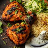 Assiette tandoori : deux poulets, riz, salade, sauce